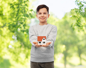 Image showing smiling boy holding house model