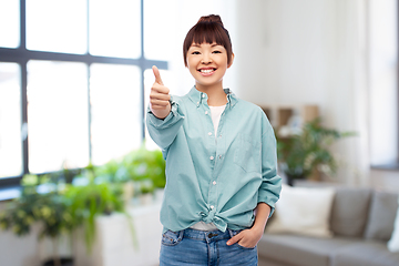 Image showing happy asian woman showing thumbs up over home