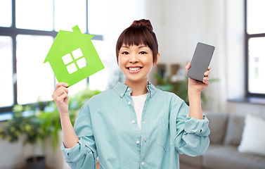 Image showing smiling asian woman holding green house