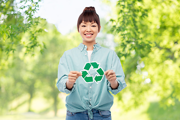 Image showing smiling asian woman holding green recycling sign