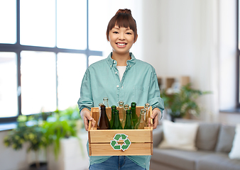 Image showing smiling young asian woman sorting glass waste