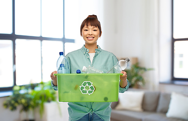 Image showing smiling young asian woman sorting plastic waste