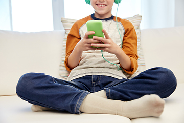 Image showing boy with headphones and smartphone at home