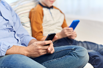 Image showing father and son with smartphones at home