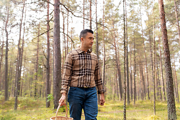 Image showing happy man with basket picking mushrooms in forest