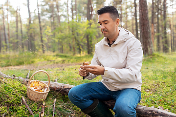 Image showing man with basket picking mushrooms in forest