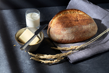 Image showing close up of bread, butter, knife and glass of milk