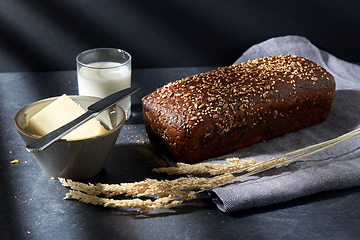 Image showing close up of bread, butter, knife and glass of milk