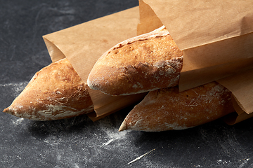 Image showing close up of baguette bread in paper bags on table