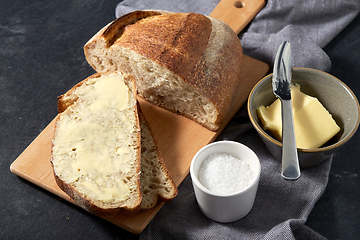 Image showing close up of bread, butter, knife and salt on towel