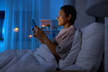 Image showing woman with tablet pc in bed at home at night