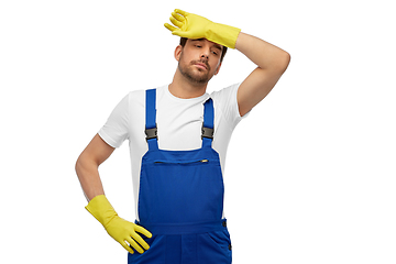 Image showing tired male worker or cleaner in overall and gloves