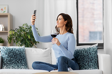 Image showing woman with smartphone and wine taking selfie