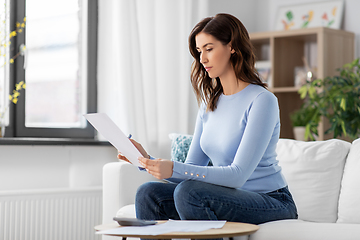 Image showing woman with papers and calculator at home