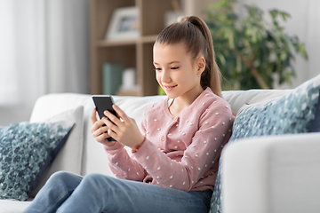 Image showing happy smiling little girl with smartphone at home