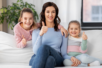 Image showing mother and daughters showing thumbs up at home