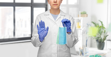 Image showing female doctor with two masks showing stop gesture