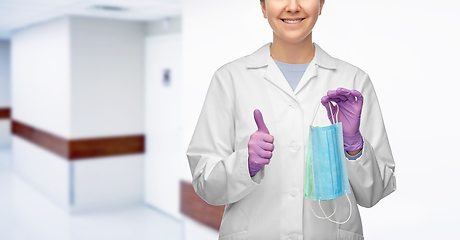 Image showing smiling doctor with two masks showing thumbs up