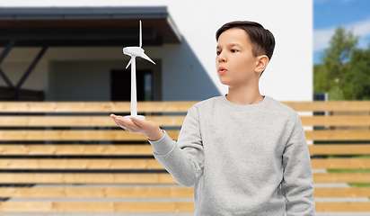 Image showing boy with toy wind turbine over house background