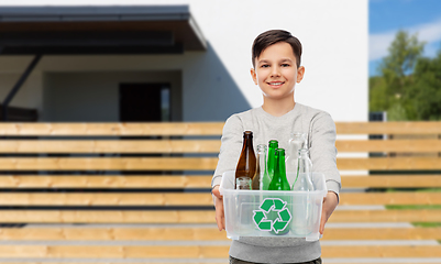 Image showing smiling boy sorting glass waste over house