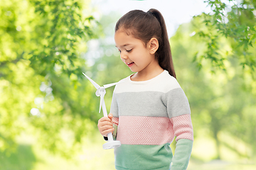 Image showing girl with toy wind turbine over natural background