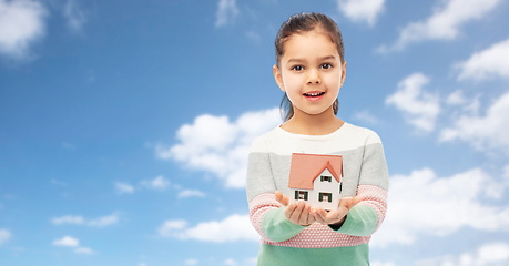 Image showing happy girl holding house model over sky and clouds