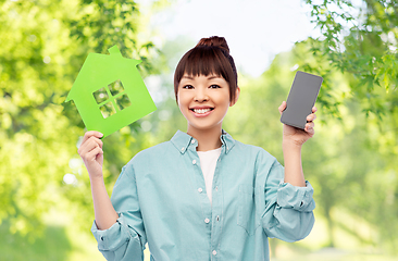 Image showing smiling asian woman holding green house