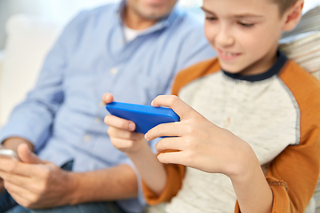 Image showing father and son with smartphones at home