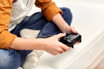 Image showing boy with gamepad playing video game at home