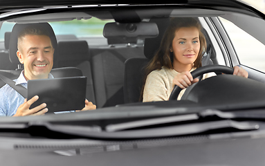 Image showing woman and driving school instructor talking in car