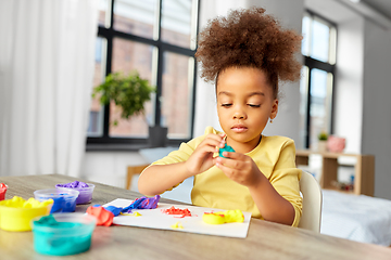 Image showing little girl with modeling clay playing at home