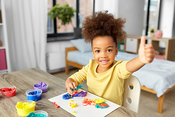 Image showing little girl with modeling clay playing at home