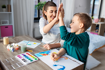 Image showing mother and son with colors drawing at home
