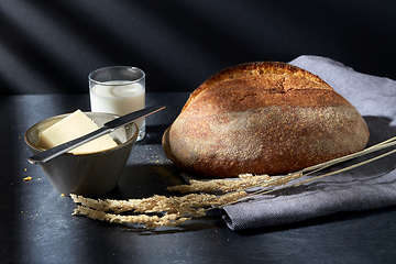 Image showing close up of bread, butter, knife and glass of milk