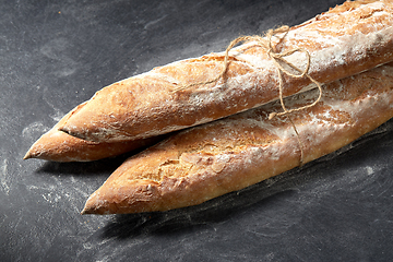 Image showing pile of baguette bread loaves tied with rope