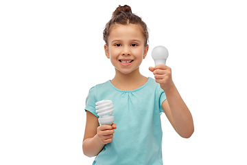 Image showing smiling girl comparing different light bulbs