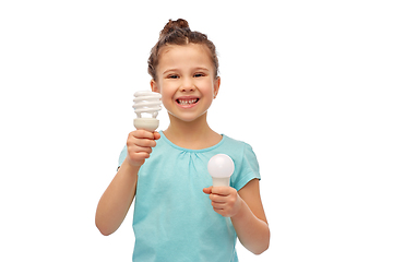 Image showing smiling girl comparing different light bulbs