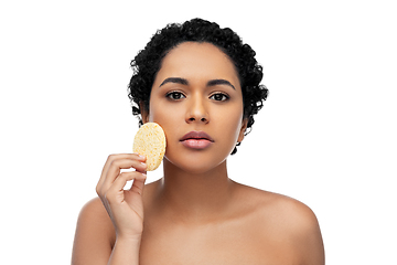 Image showing young woman cleaning face with exfoliating sponge