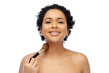 Image showing woman with make up brush applying shimmer to skin