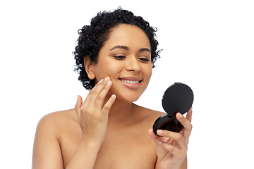 Image showing smiling african american woman looking to mirror