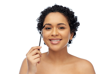 Image showing smiling african american woman with mascara brush