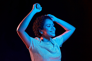 Image showing african american woman dancing over neon lights