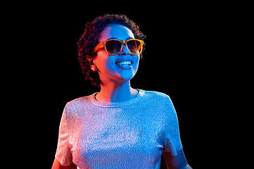 Image showing african woman in sunglasses over neon lights