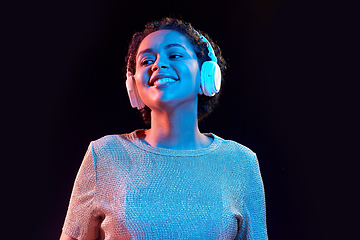 Image showing woman in headphones listening to music and dancing