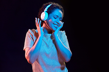 Image showing woman in headphones listening to music and dancing