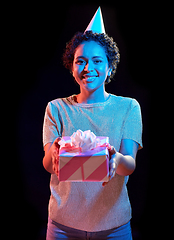 Image showing african woman in party cap with gift box on black