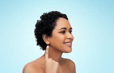 Image showing smiling african american woman showing her ear