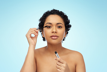 Image showing beautiful african american woman applying mascara