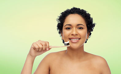 Image showing smiling woman with toothbrush cleaning teeth