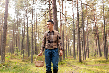 Image showing happy man with basket picking mushrooms in forest